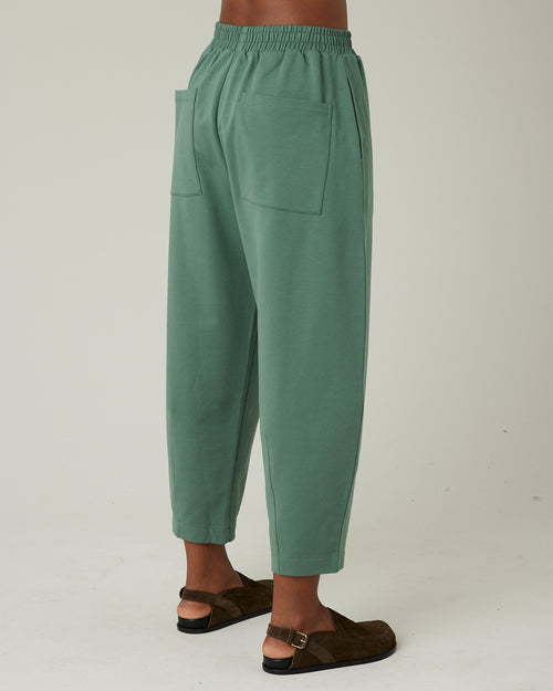 model wears dusty green huxley jersey trousers right