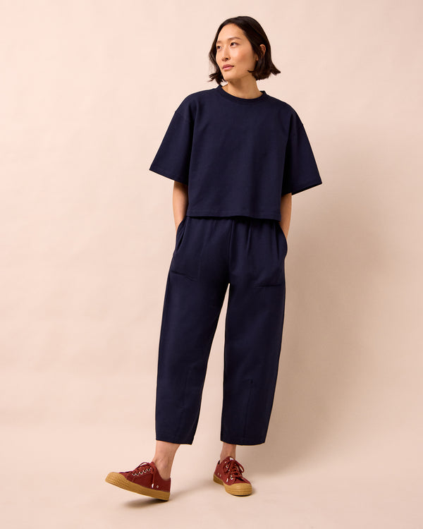 model wears huxley ink jersey trousers left