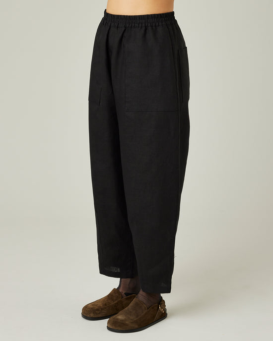 model wears black linen huxley trousers left