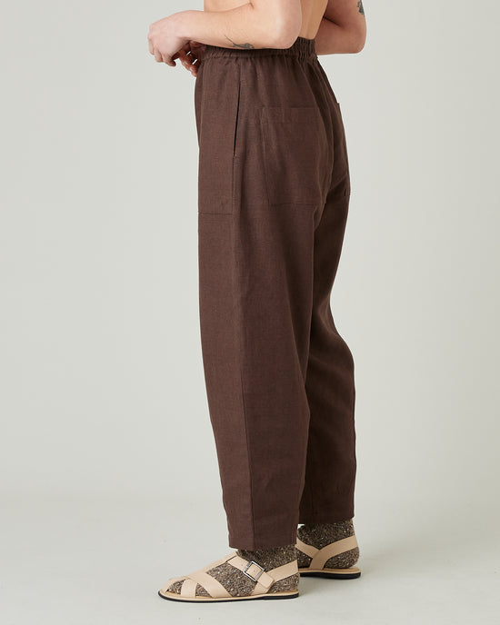 model wears brown huxley linen trousers left