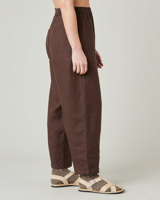 model wears brown huxley linen trousers right