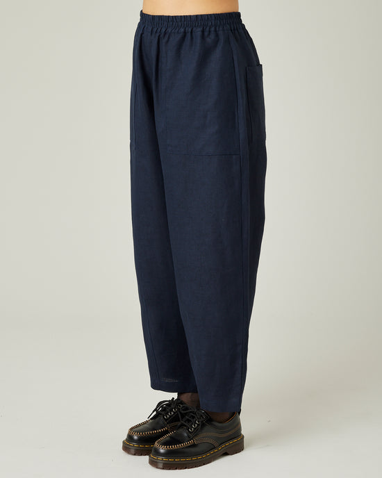 model wears navy huxley linen trousers left