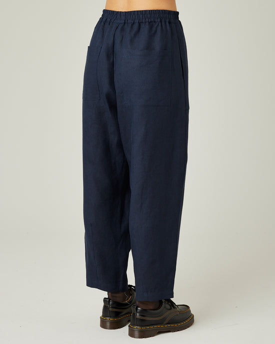 model wears navy huxley linen trousers right