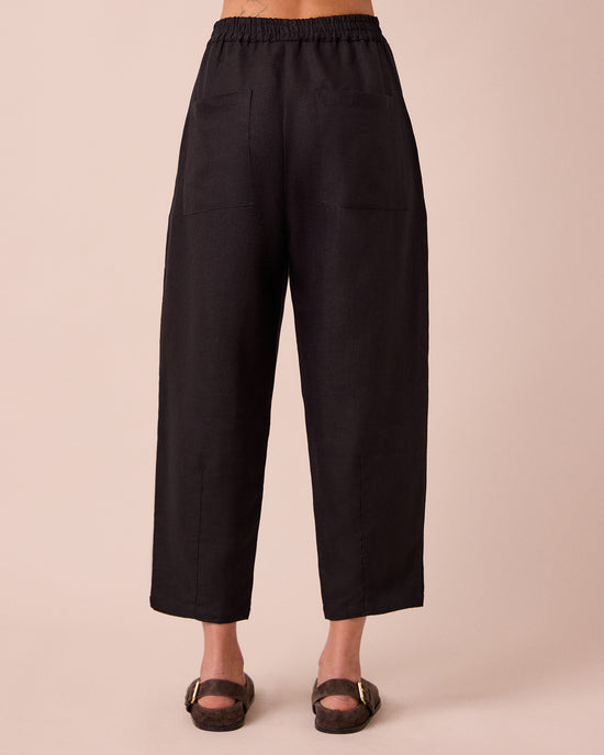 model wears huxley black linen trousers back