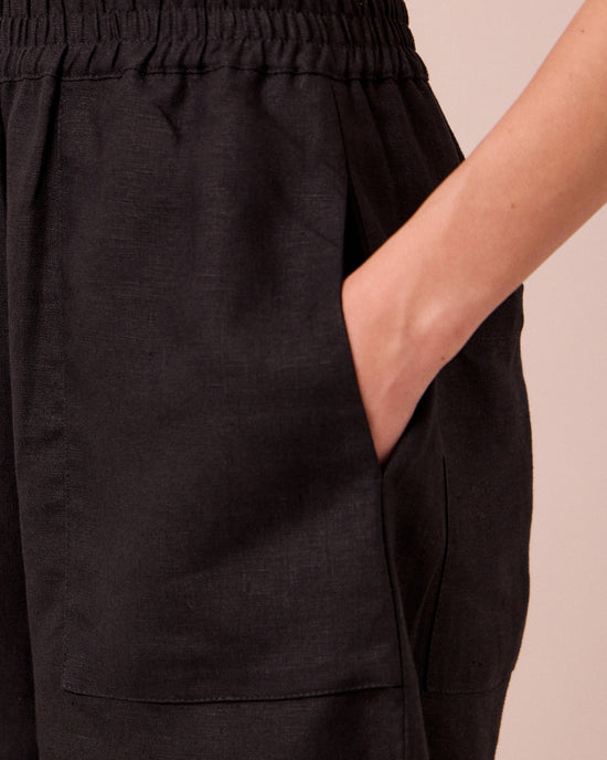 model wears huxley black linen trousers