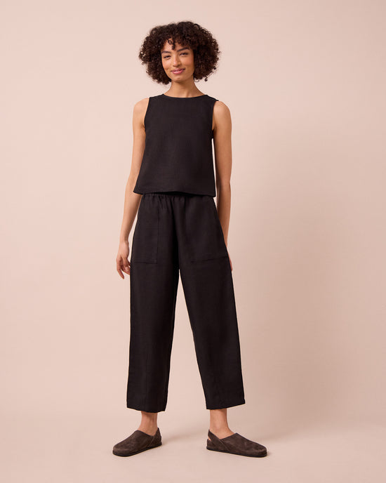 model wears huxley black linen trousers left