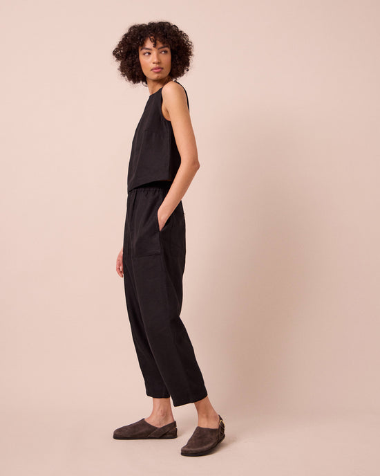 model wears huxley black linen trousers right