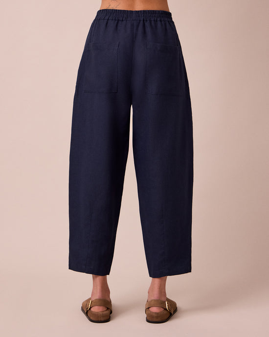 model wears huxley navy linen trousers back