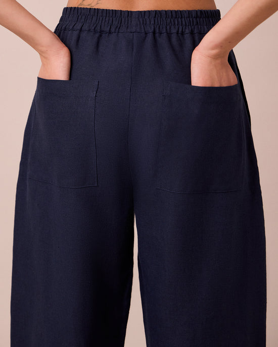 model wears huxley navy linen trousers