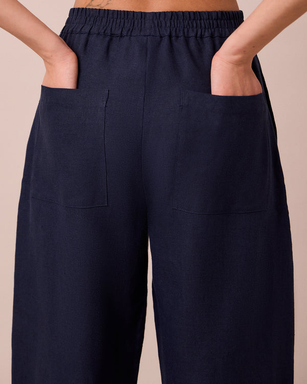 model wears huxley navy linen trousers
