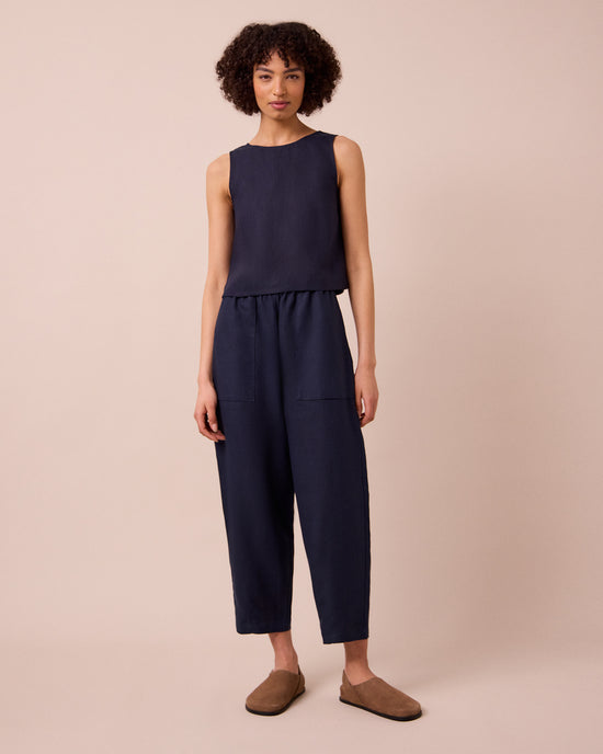 model wears huxley navy linen trousers left