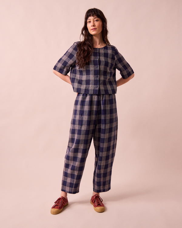 model wears huxley navy plaid linen trousers left