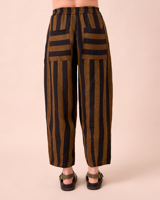 model wears huxley rust stripe linen trousers back