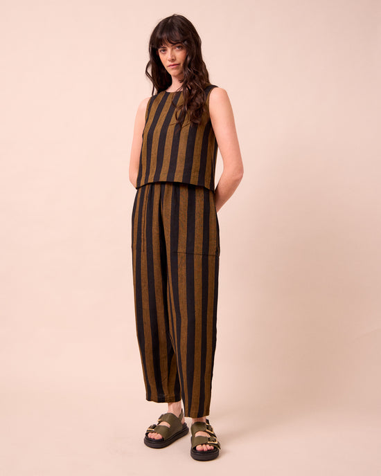 model wears huxley rust stripe linen trousers left