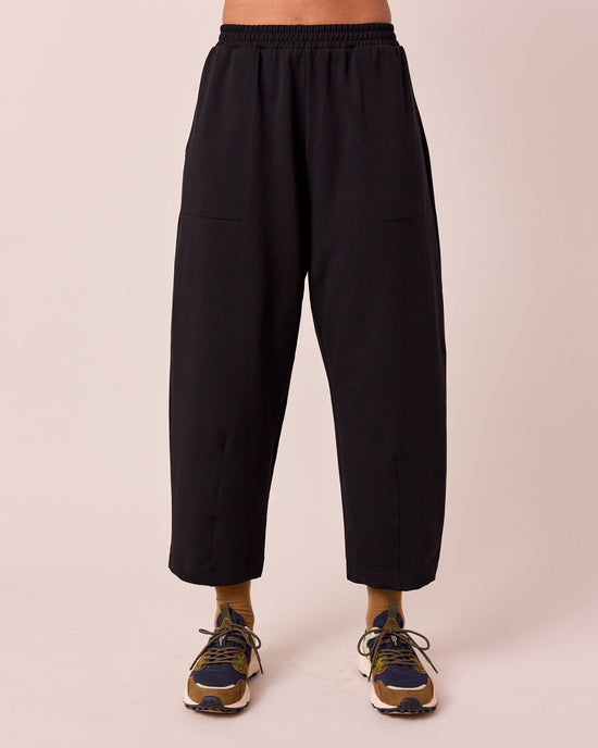 model wears huxley black jersey trousers front