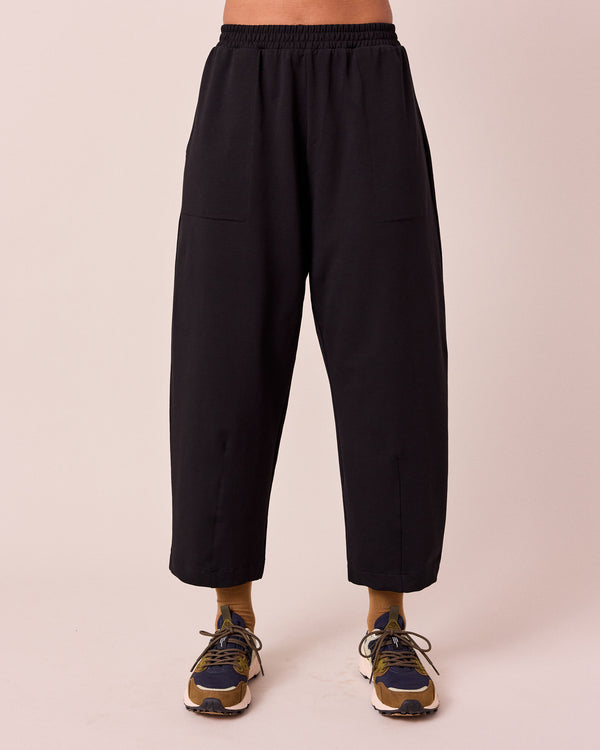 model wears huxley black jersey trousers front