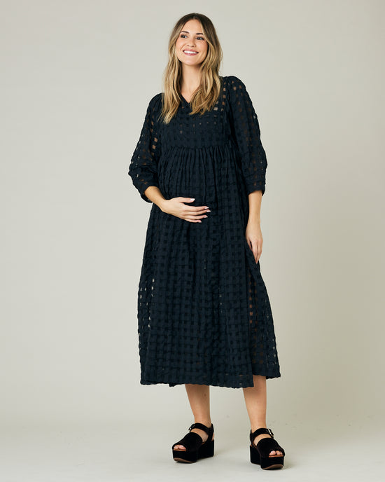 pregnant model wears black organza izzy dress