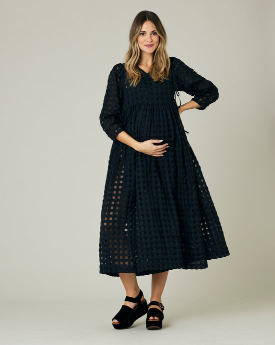 pregnant model wears black organza izzy dress