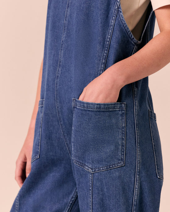 model wears jolie mid blue denim jumpsuit