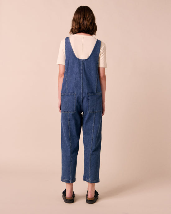 model wears jolie mid blue denim jumpsuit