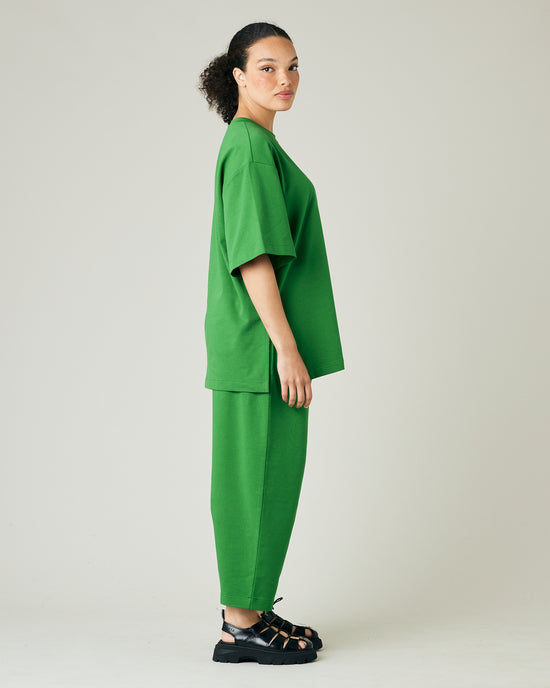 model wears juniper green huxley jersey trousers