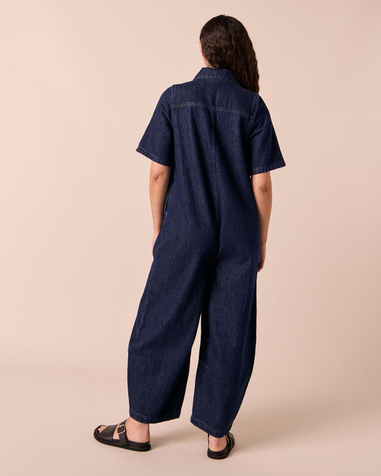 model wears juno dark wash denim jumpsuit.