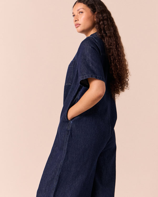 model wears juno dark wash denim jumpsuit.