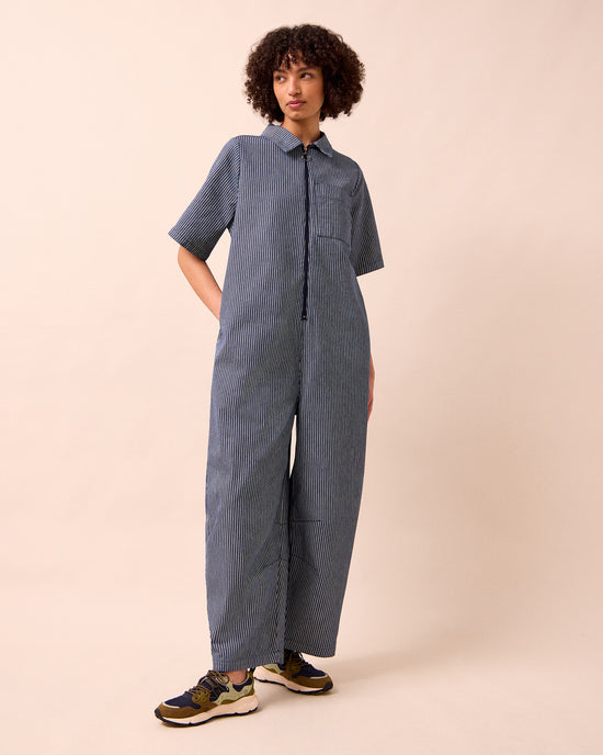 model wears juni navy hickory stripe denim jumpsuit