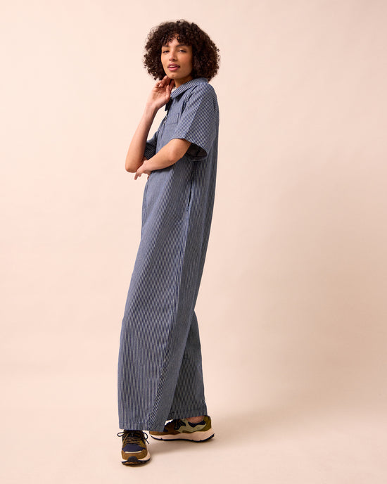 model wears juni navy hickory stripe denim jumpsuit