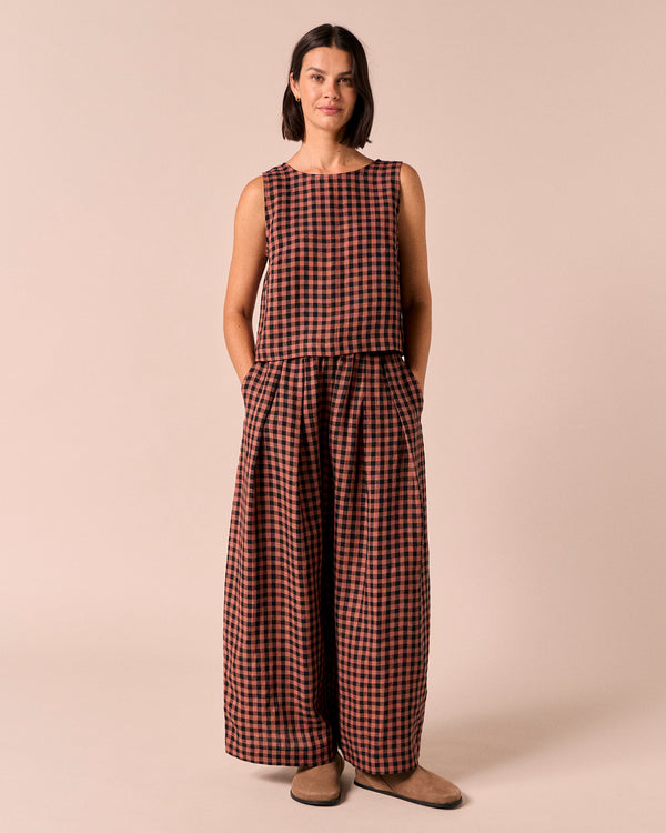 model wears layne dried rose gingham linen trousers right
