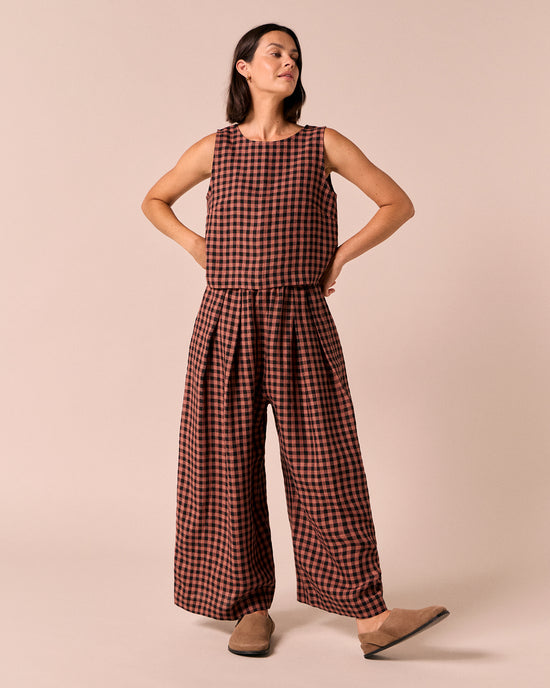 model wears layne dried rose gingham linen trousers left