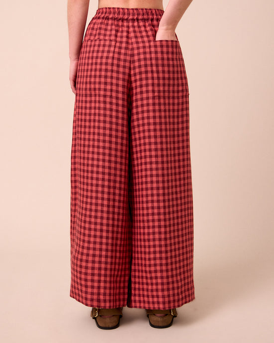 model wears layne deep rose gingham linen trousers back