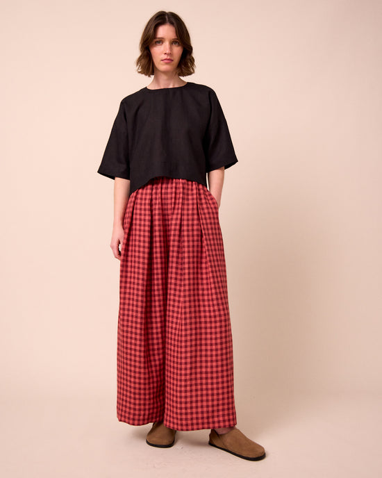 model wears layne deep rose gingham linen trousers left