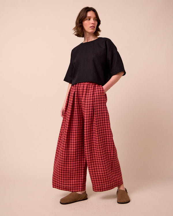 model wears layne deep rose gingham linen trousers right