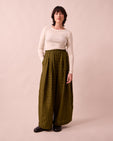model wears layne fresh olive mini gingham linen trousers left