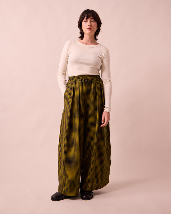 model wears layne fresh olive mini gingham linen trousers left