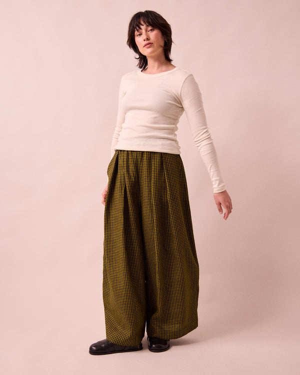 model wears layne fresh olive mini gingham linen trousers right