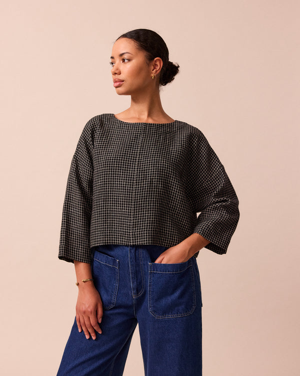 model wears lily black mini grid linen top