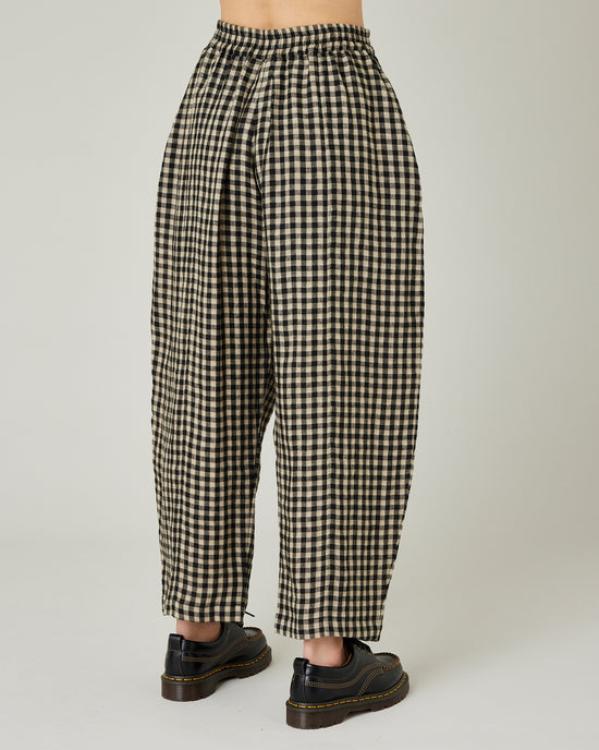 model wears black and ecru check mabel trousers right