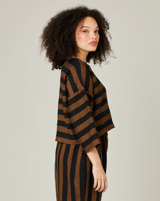 model wears linen rust and black stripe lily top