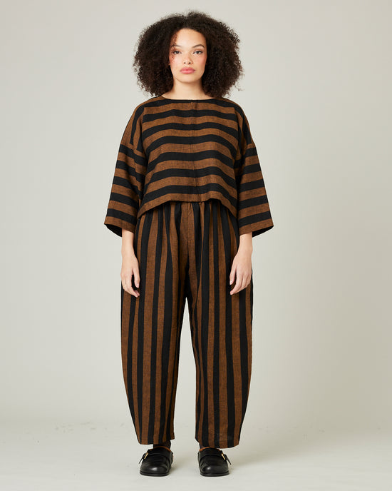 model wears linen rust and black stripe lily top