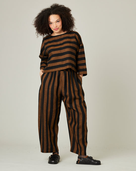 model wears linen rust and black stripe lily top