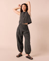 model wears logan black and ecru pencil stripe linen trousers. 