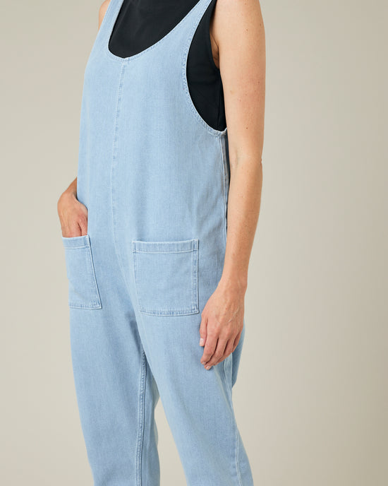 model wears light wash denim lola jumpsuit 