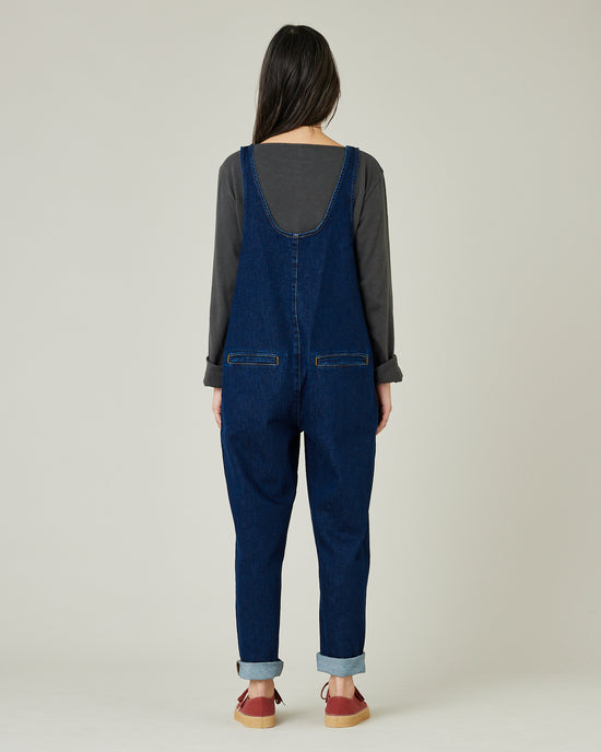 model wears dark wash denim lola jumpsuit