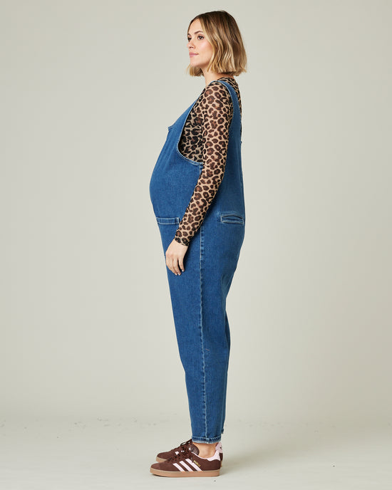 pregnant model wears mid blue lola denim jumpsuit