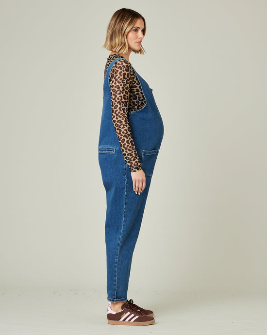 pregnant model wears mid blue lola denim jumpsuit