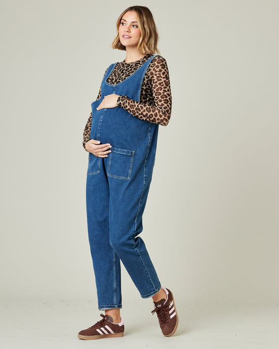 pregnant model wears mid blue lola denim jumpsuit