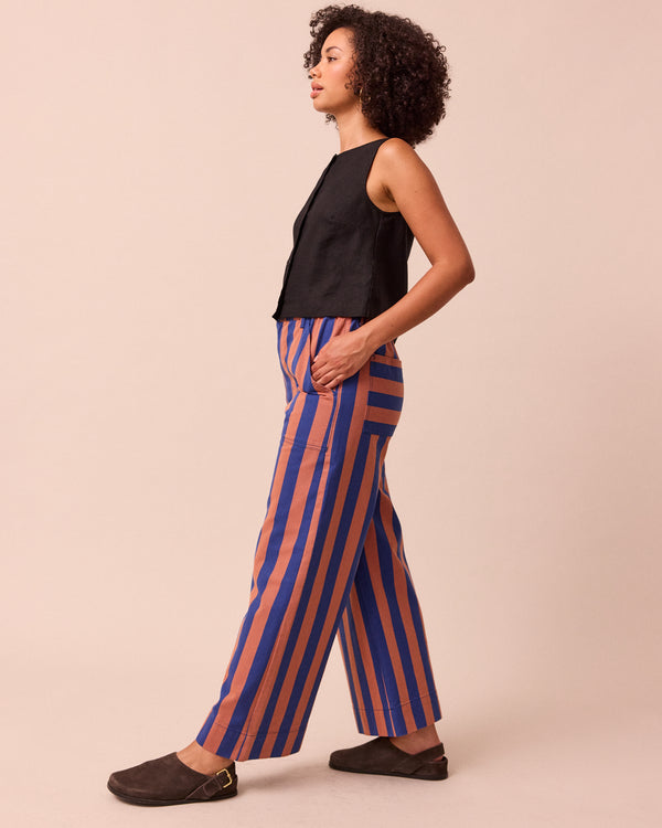 model wears luca cobalt and terracotta stripe denim trousers left
