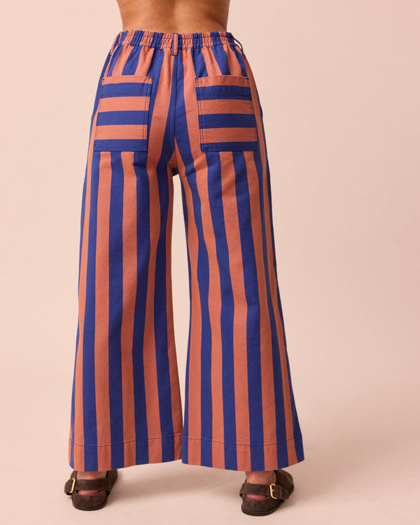 model wears luca cobalt and terracotta stripe denim trousers back